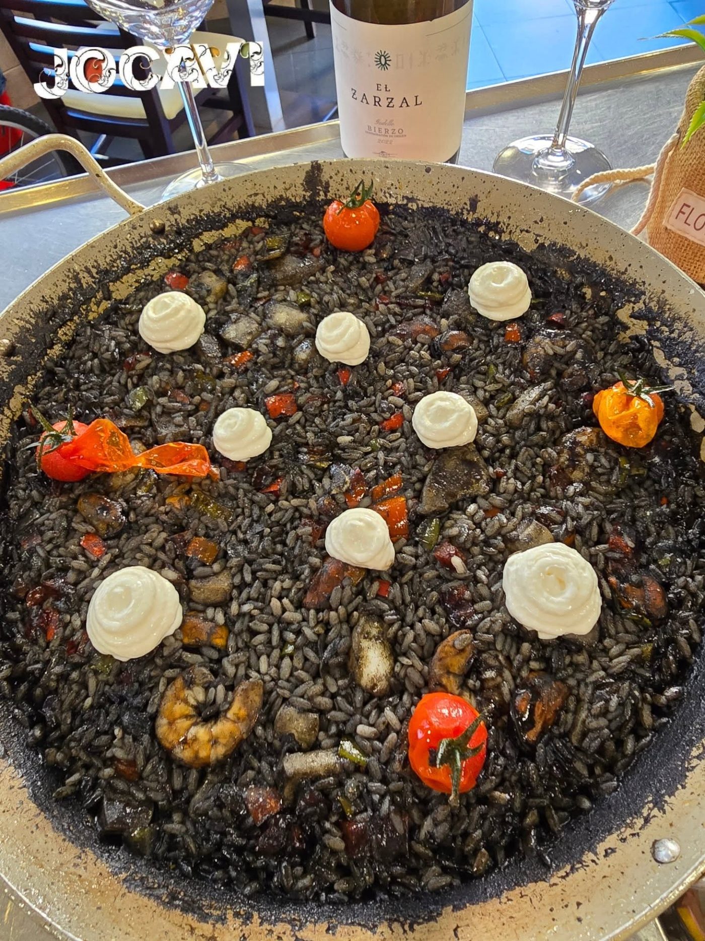 Squid ink rice with aioli, prawns and peppers, in a pan to share