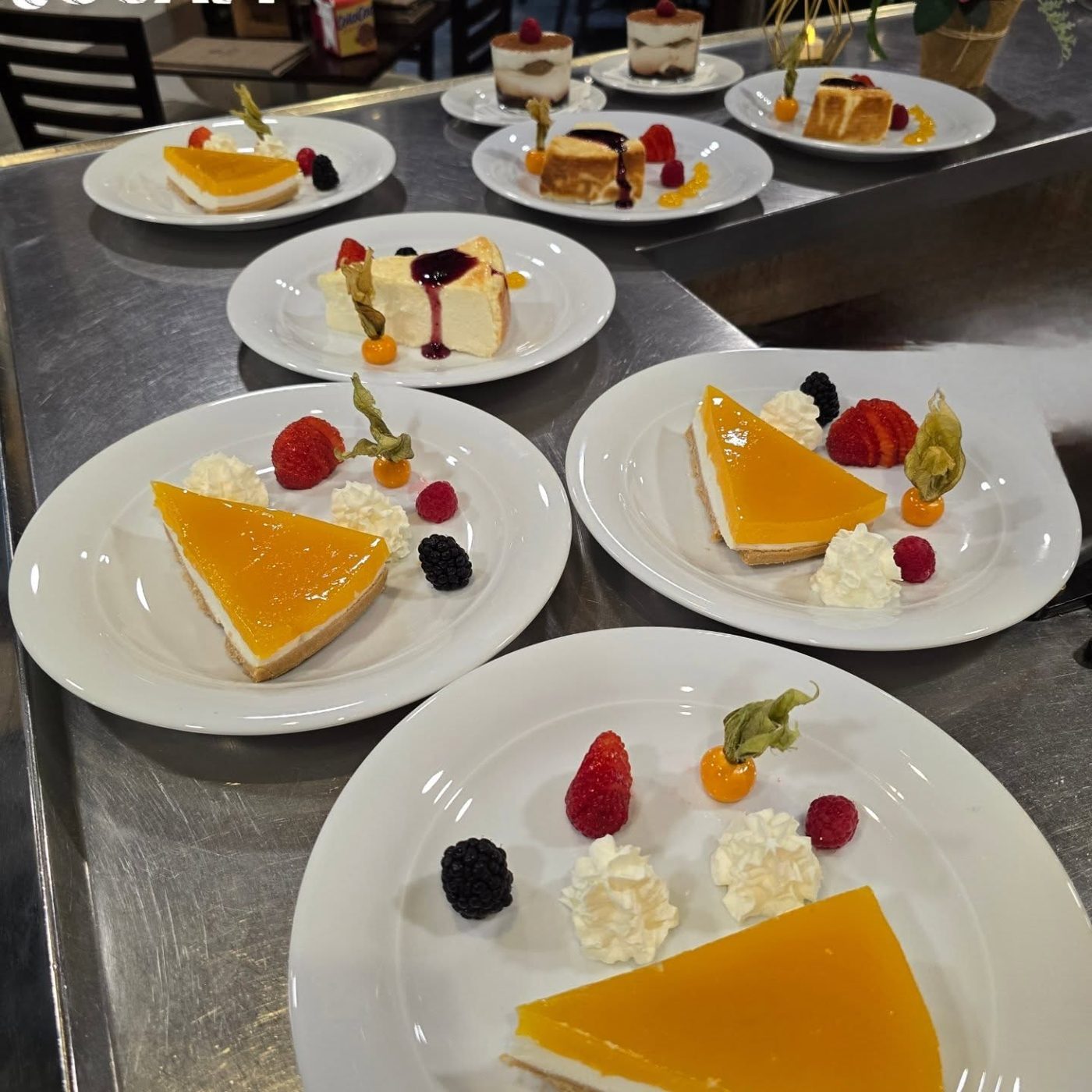 An assortment of house desserts plated with red berries