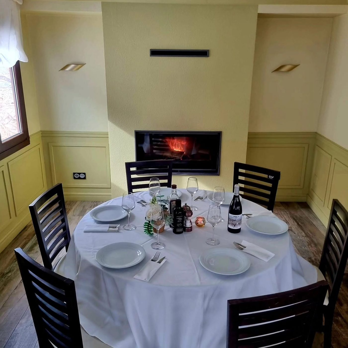 Jocavi's upstairs room with a fireplace and a round table set for a celebration